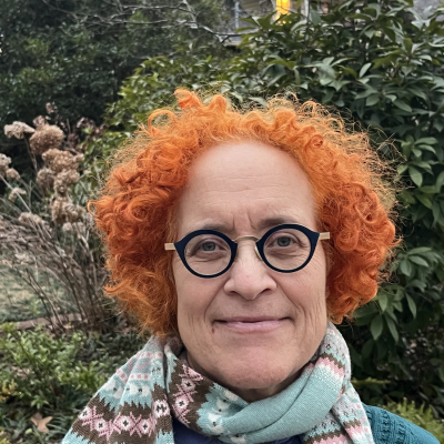 Tamara Levitz stands in front of flowering foliage.