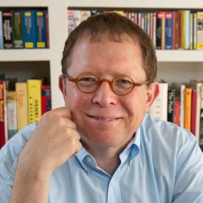 Headshot of Efrain Kristal seated in front of a bookshelf.
