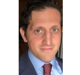 Headshot of Ethan Pack in a navy suit.